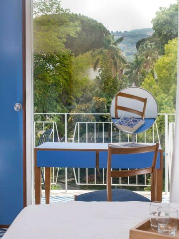 Hotelzimmer mit Schreibtisch und Balkon mit Blick ins Grüne