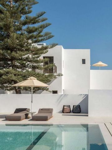 Pool mit Liegestühlen in modernem Design und Blick auf weiße Gebäude