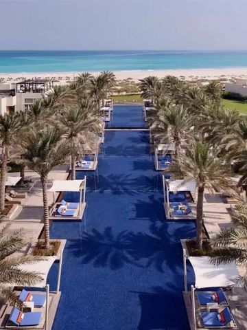 Langer Pool mit Sonnenliegen und direktem Zugang zum Strand