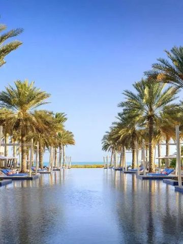 Großer Pool mit Palmen und Blick auf das Meer