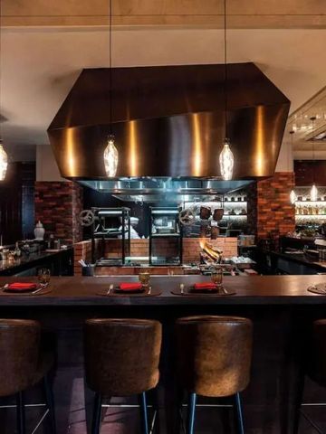 Stilvolles Restaurant mit offener Küche und eleganter Einrichtung.