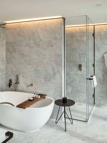 Luxuriöses Badezimmer mit freistehender Badewanne und Regendusche