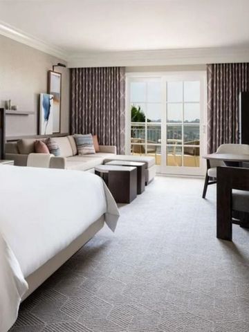 Elegantes Hotelzimmer mit komfortablem Bett und Ausblick auf Garten