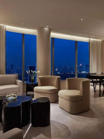 Elegantes Wohnzimmer mit Panoramafenstern und nächtlichem Stadtblick