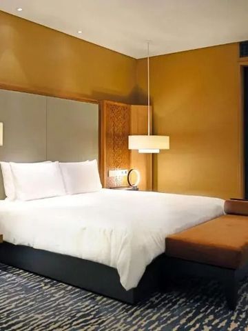 Luxuriöses Hotelzimmer mit weichem Bett und warmen Farbtönen