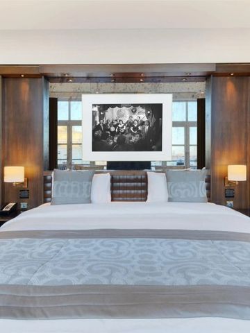 Hotelzimmer mit großem Bett und eleganter Holzeinrichtung