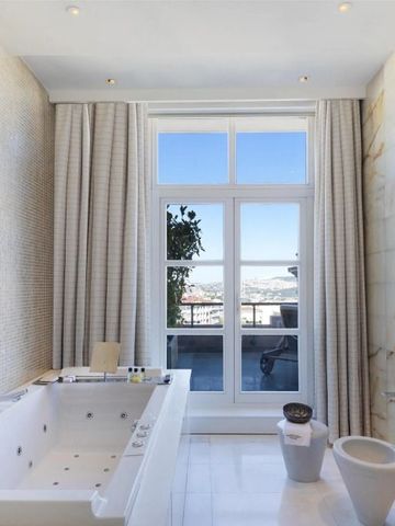 Helles Badezimmer mit Whirlpool und Blick auf die Stadt