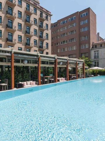 Außenpoolbereich mit angrenzender Terrasse in sonniger Umgebung.