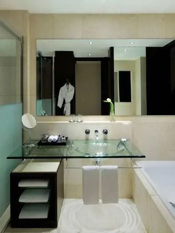 Modernes Badezimmer mit Glaswaschtisch und großem Spiegel