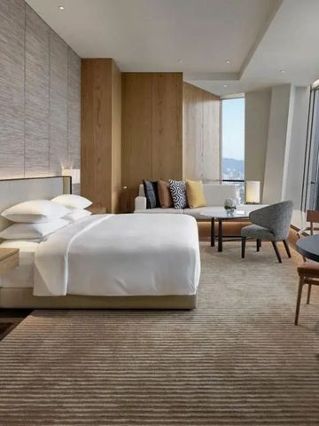 Modernes Hotelzimmer mit großem Bett und Panoramablick auf die Stadt