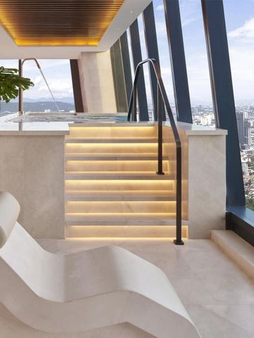 Spa-Bereich mit Liegestuhl und städtischer Aussicht durch große Fenster