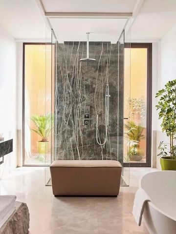 Großzügige Dusche und freistehende Badewanne im modernen Design