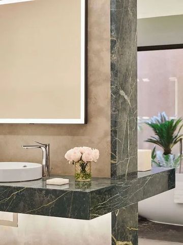 Elegantes Badezimmer mit Marmorwaschtisch und Sicht auf eine Badewanne im Freien