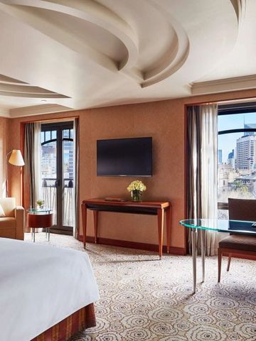 Zimmer mit großem Fenster Blick auf die Stadt und eleganter Einrichtung