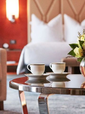 Nahaufnahme eines eleganten Hotelzimmers mit Blumen und Tassen
