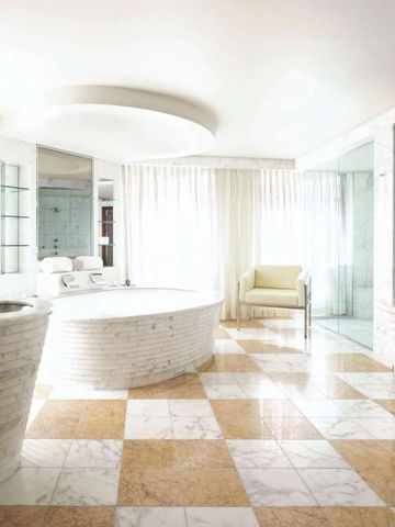 Helles Badezimmer mit großer Badewanne und Marmorbodenfliesen