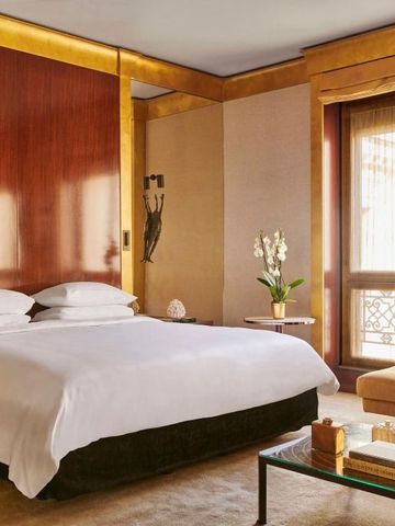 Luxuriöses Schlafzimmer mit großem Bett und elegantem Holzwandpaneel