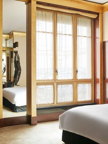 Schlafzimmer mit großen Fenstern und stilvollen Holzelementen