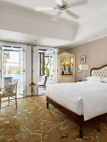 Geräumiges Zimmer mit King-Size-Bett, eleganter Einrichtung und Zugang zu einem Balkon.