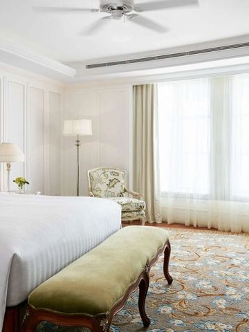 Helles Schlafzimmer mit großem Fenster und luxuriösen Möbeln im klassischen Stil.