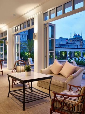 Lounge-Bereich mit gemütlichen Sitzmöbeln und Blick auf die Stadt bei Dämmerung.