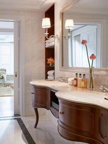 Luxuriöses Badezimmer mit Doppelwaschtisch, großen Spiegeln und eleganter Einrichtung.