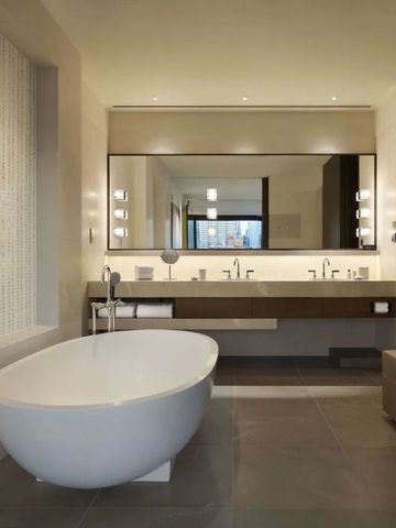 Modernes Badezimmer mit freistehender Badewanne und großem Spiegel