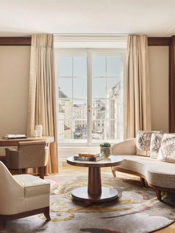 Elegantes Wohnzimmer in einer Suite mit Sofa, Tisch und großem Fenster