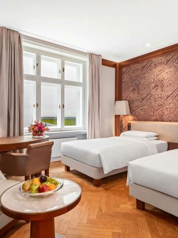 Doppelzimmer mit zwei Betten, klassischem Holzfußboden und floralem Wandschmuck