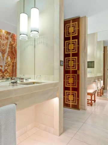 Luxuriöses Badezimmer mit Marmorwänden und eleganter Beleuchtung