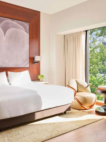 Luxuriöses Hotelzimmer mit großem Fenster und eleganter Einrichtung.