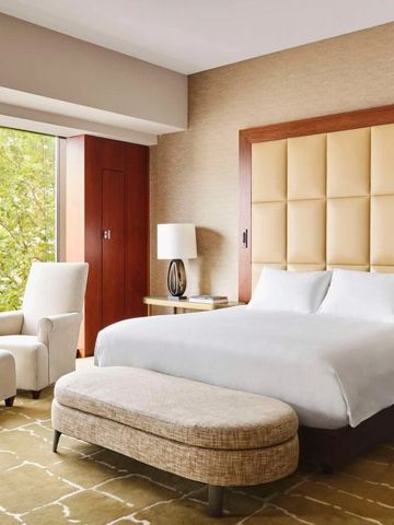 Geräumiges Hotelzimmer mit komfortablem Bett und Sitzgelegenheiten.