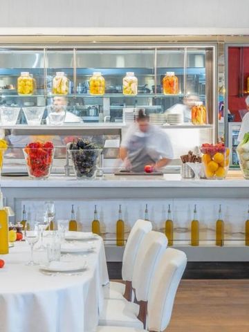 Modernes Restaurant mit offener Küche und reich gedecktem Tisch