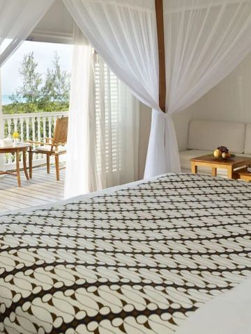 Schlafbereich mit Baldachin und Zugang zum Balkon mit Sitzbereich