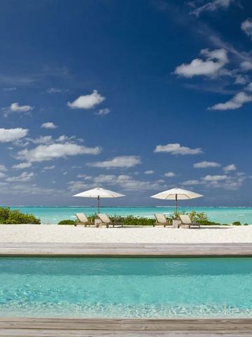 Weiße Sandstrände und türkisblaues Wasser mit Liegestühlen unter Sonnenschirmen