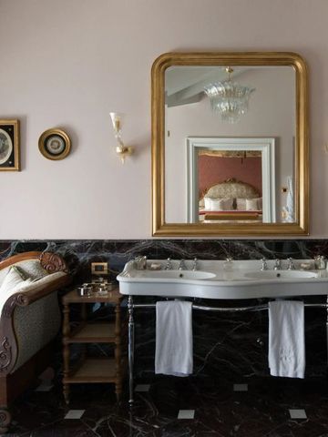 Luxuriöser Wohnbereich mit antikem Spiegel und eleganter Chaiselongue