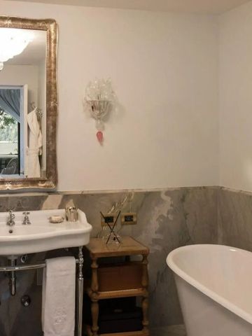 Elegantes Badezimmer mit antikem Spiegel und freistehender Badewanne