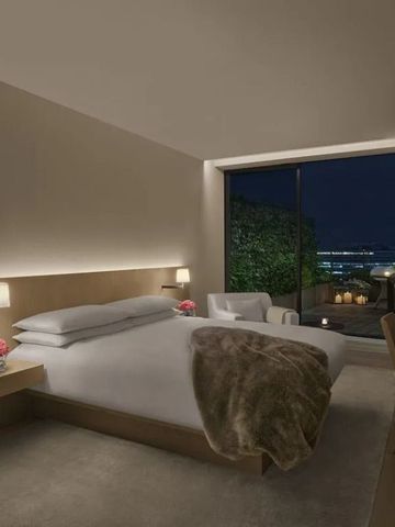 Modernes Hotelzimmer mit Blick auf die Stadt bei Nacht und Terrasse