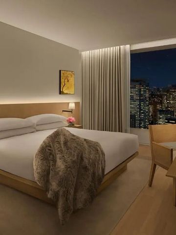 Elegant eingerichtetes Schlafzimmer mit nächtlicher Stadtansicht