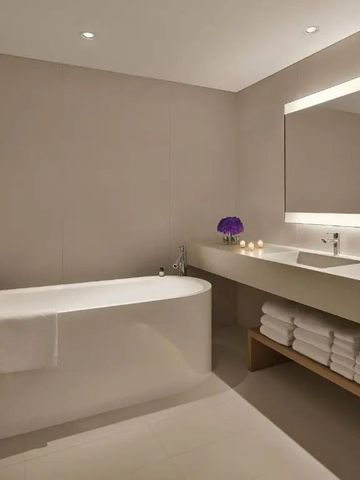 Modernes Badezimmer mit freistehender Badewanne und eleganter Beleuchtung