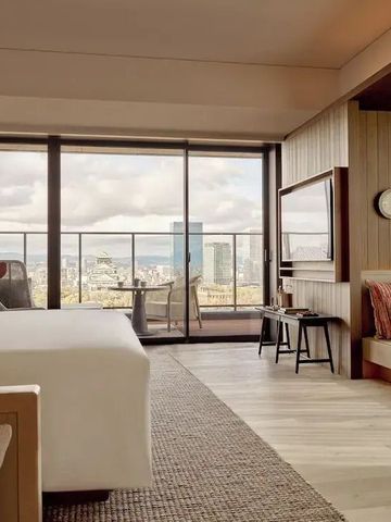 Hotelzimmer mit großem Fenster und Blick auf die Stadt