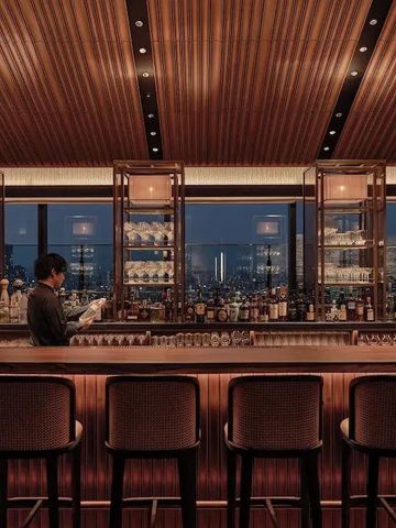 Elegante Hotelbar mit warmem Holzdesign und Stadtblick.