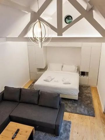 Modernes Schlafzimmer mit Holzbalken und gemütlicher Sitzecke