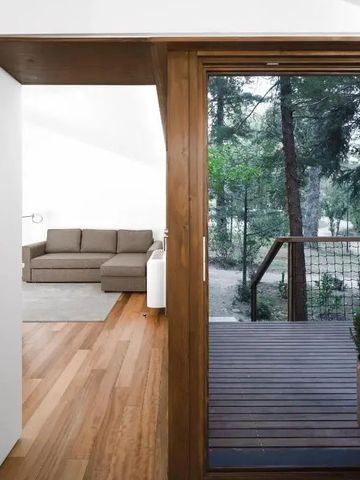 Zimmer mit Zugang zu einer Holztür und Blick auf den Wald