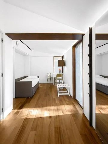 Heller Raum mit Holzboden und zwei Sofas sowie Tisch