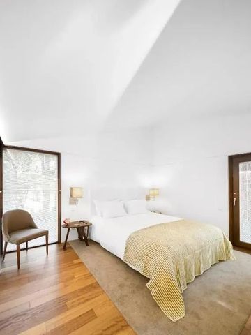 Helles Schlafzimmer mit Doppelbett und zwei Fenstern