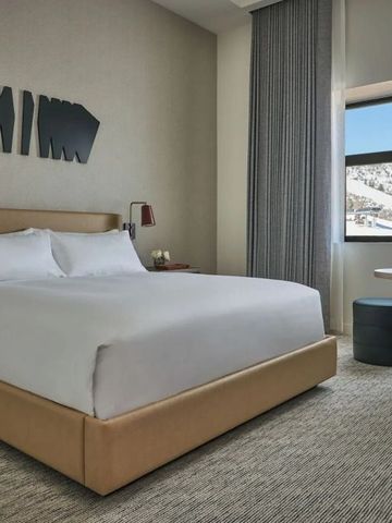 Helles Zimmer mit großem Bett und Blick auf Schneelandschaft