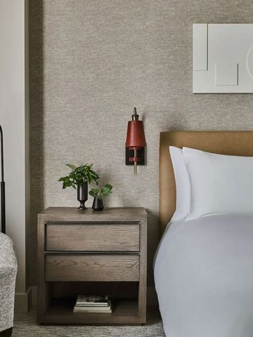 Elegantes Hotelzimmer mit modernem Dekor und bequemen Bett, graue Wandfarbe