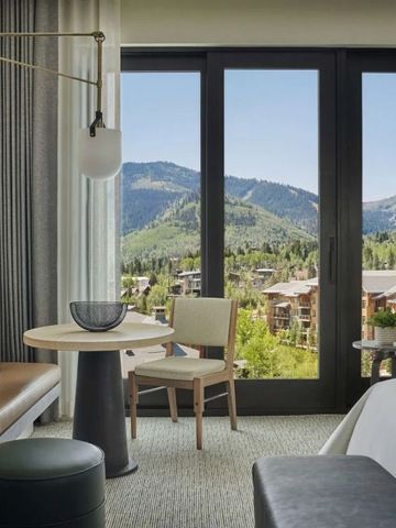 Luxus-Zimmer mit Blick auf Berge durch große Fenster und komfortabler Sitzecke