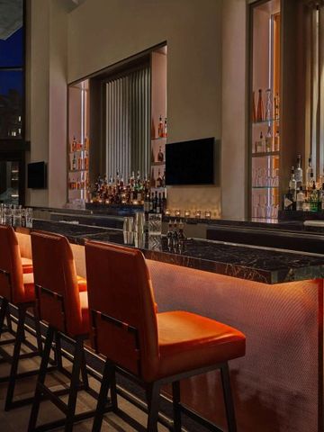 Stilvolle Bar mit hohen Stühlen und breitem Getränkesortiment